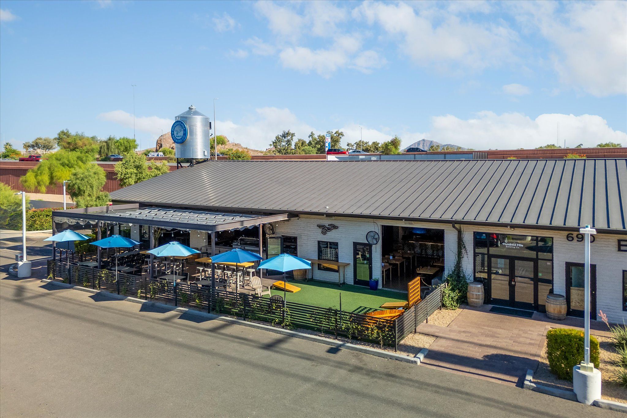 Hundred Mile Brewing exterior with patio and blue umbrellas
