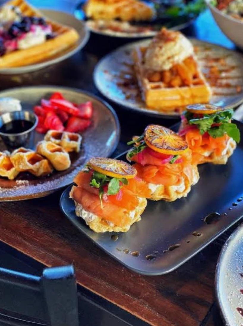 Smoked salmon waffles with pickled onion and arugula at Honey & Herb